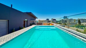 Una piscina en la azotea con vistas despejadas del horizonte urbano.