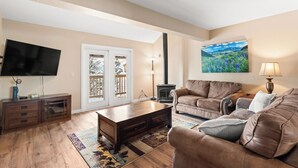 A living room with a sofa, coffee table, TV, and a fireplace.
