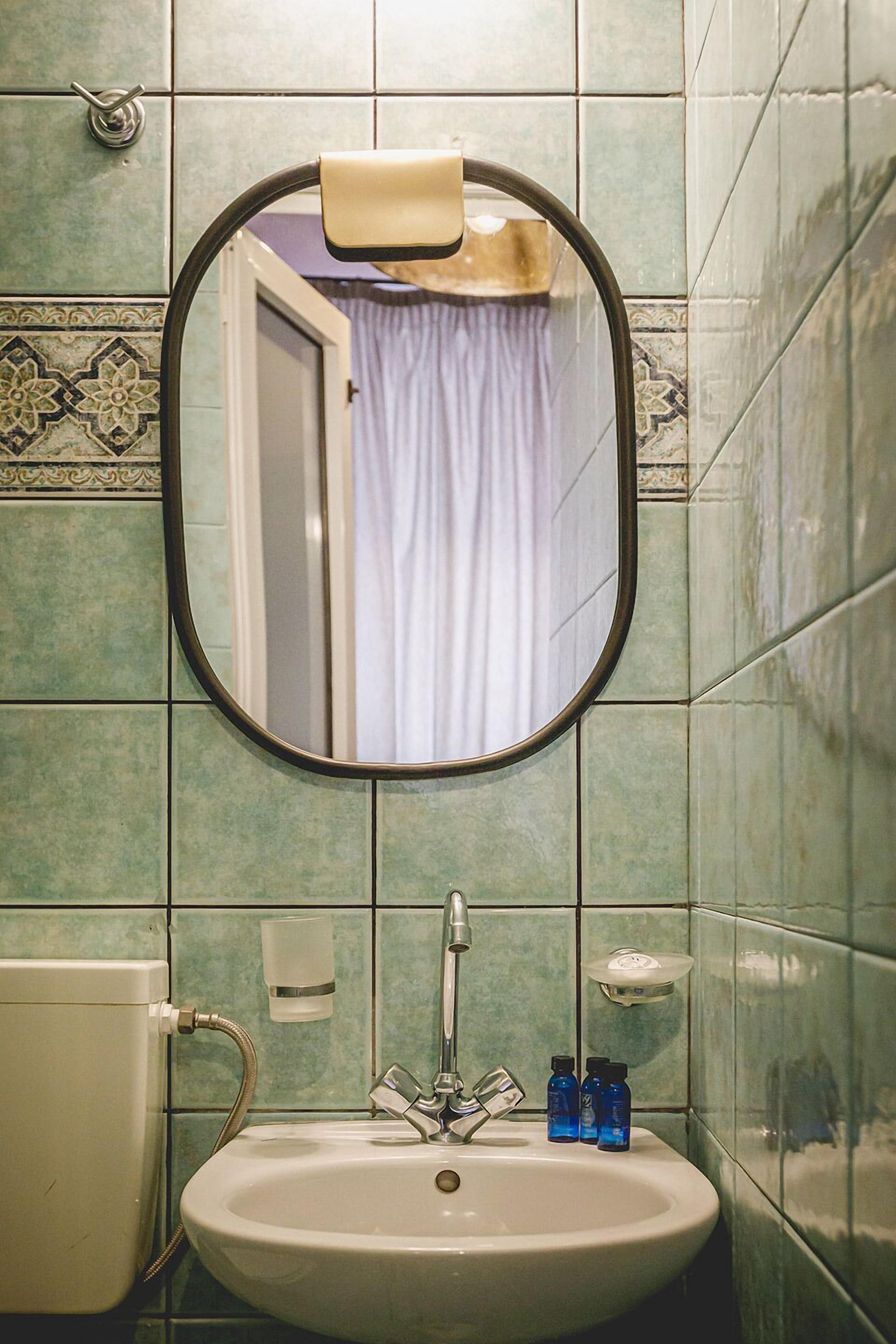 A bathroom with a sink, mirror, and a shower curtain.