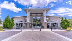 A modern building with a central entrance, surrounded by landscaped areas and trees. - 2614 Veranda Palms (Kissimmee)
