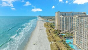 A beachfront hotel with multiple balconies, a swimming pool, and a beach view. - 🌊Oceanfront | Amazing Views | Fabulous Amenities | Beach Cove Resort 1020⛱️ (North Myrtle Beach)