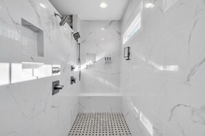 A modern bathroom with a shower, a sink, and a toilet. - Durham Retreat Games, Exercise, And Relaxation 5 Bedroom Home (Durham)