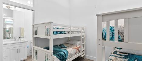 A bunk bed room with a bathroom and a mirror.