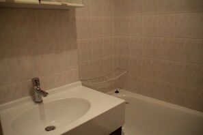 A bathroom with a white sink, a mirror, and a bathtub. - Violettes VL2 Telecabine & Nature 4 Pers (Chatel)