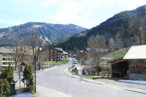 Una carretera de montaña con edificios y una estructura de madera que dice "Scierie de Village".