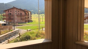 Une chambre avec vue sur un immeuble et une montagne.