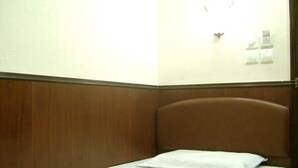 A small, single-bed room with a wooden headboard and a white mattress. - LIS CHAIN HOSTEL (Kowloon)