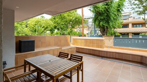 Une terrasse avec une table et des chaises en bois, un banc intégré et une vue sur les environs.