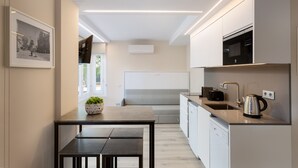 A modern kitchen with a dining area, built-in appliances, and a large window. - Mestral - Aparthotel with Swimming Pool (Vilassar de Mar)