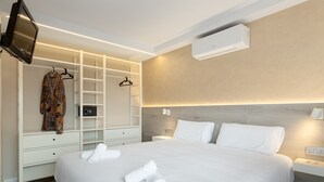 A modern hotel room with a large bed, a walk-in closet, and a TV. - Xaloc - Aparthotel with Swimming Pool (Vilassar de Mar)