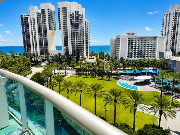 A resort with high-rise buildings, a pool area, and palm trees.