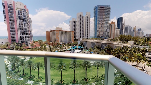 A high-rise hotel with multiple floors, a pool area, and a view of the ocean. - One Bedroom Ocean View  OR-925 (Sunny Isles)