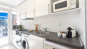 A modern kitchen with white cabinets, stainless steel appliances, a built-in oven, and a microwave. - Cosy apartment near the beach in a quiet area · 240 UHC EL CRANC (Salou)