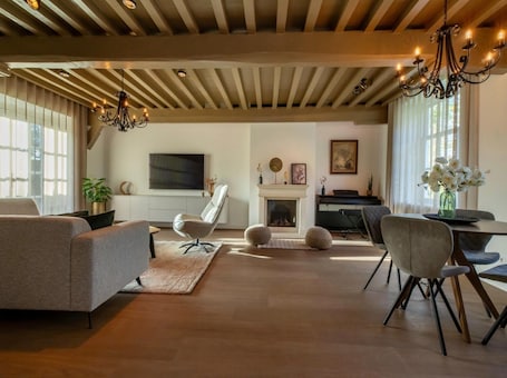 A modern living room with a fireplace, a television, and a piano.