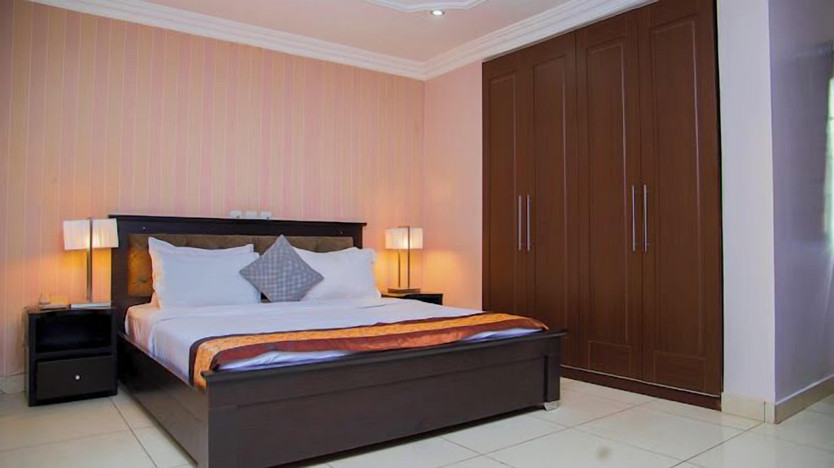 A bedroom with a bed, nightstands, and a wardrobe.