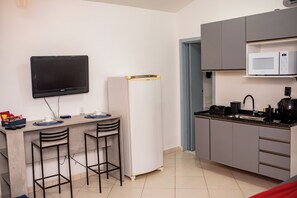 Een koelkast, een magnetron, kookgerei, borden en bestek