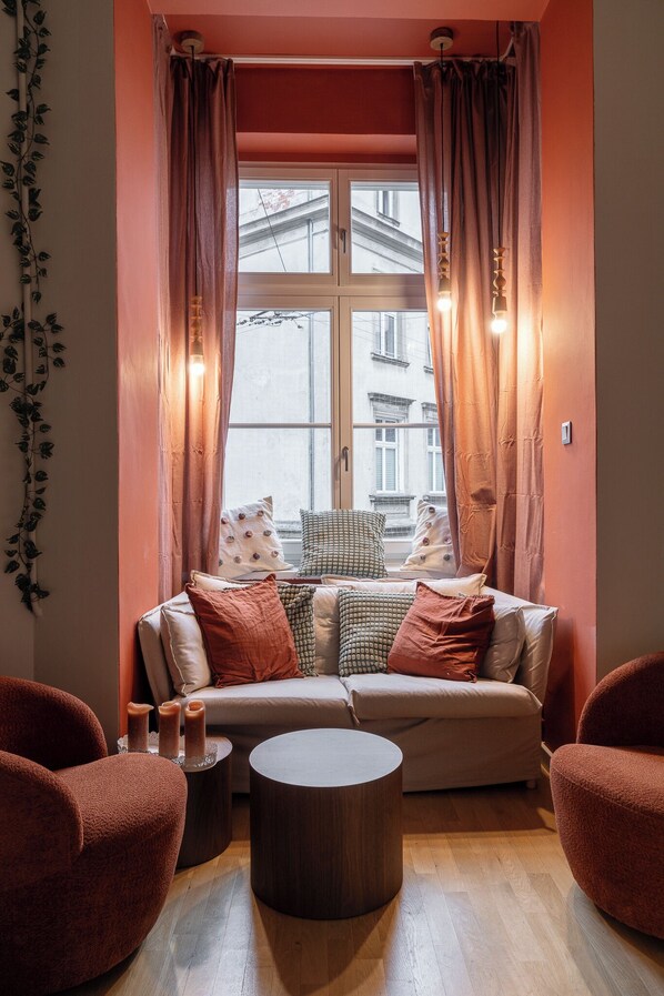A cozy seating area with a sofa, two armchairs, and a round coffee table. - RentPlanet - Apartament Nożownicza (Wroclaw)