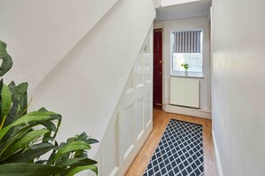 A staircase with a patterned rug, a radiator, and a window with blinds. - Host & Stay | Milford Road (Birmingham)