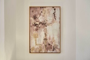 A framed abstract painting on a plain wall.