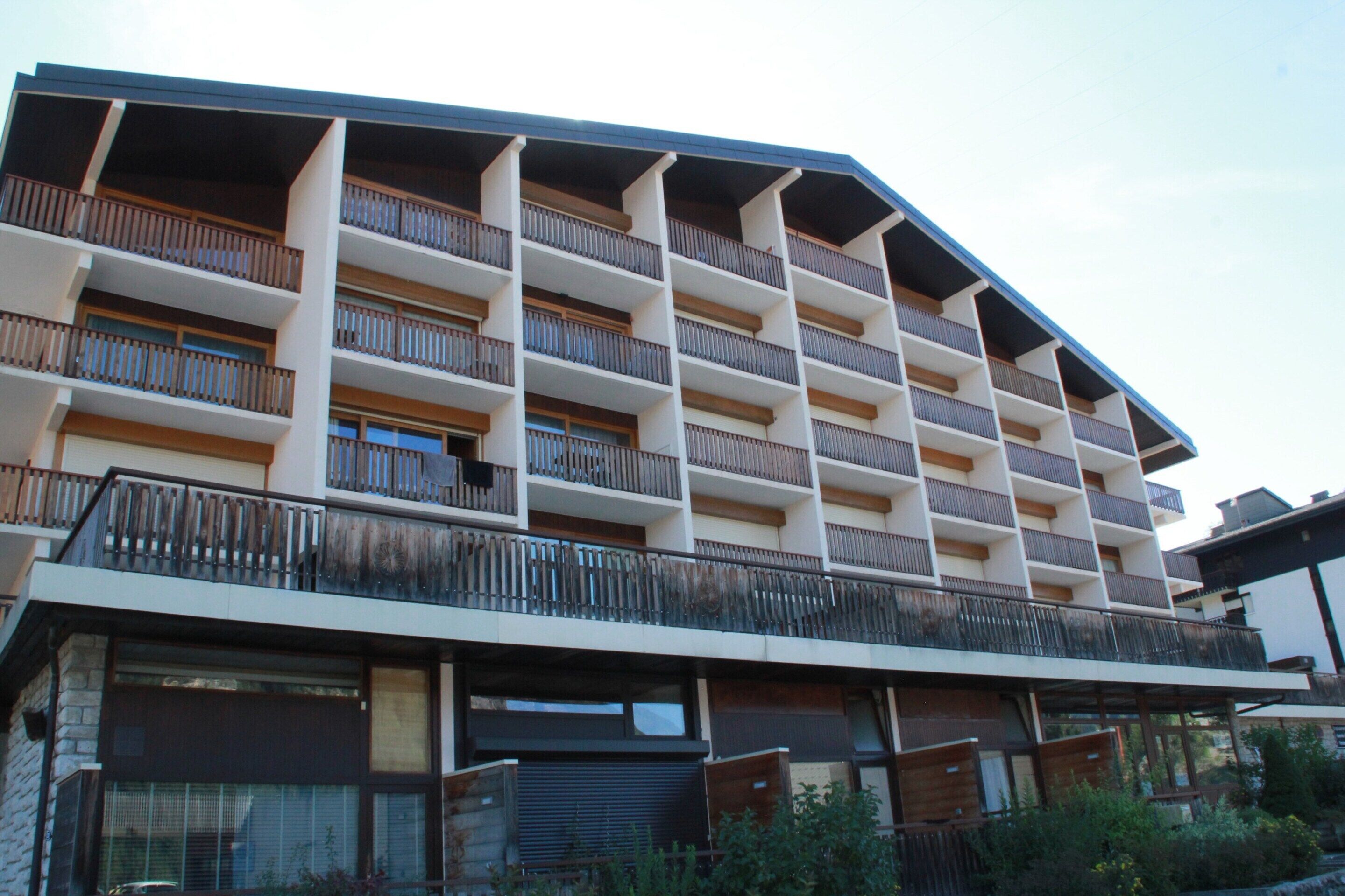 A multi-story hotel with balconies, large windows, and a modern architectural design.