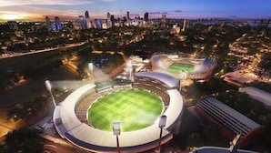 A stadium with a central field surrounded by seating areas, a large parking lot, and a city skyline in the background. - Duffotel Paddington LUXE (Paddington)