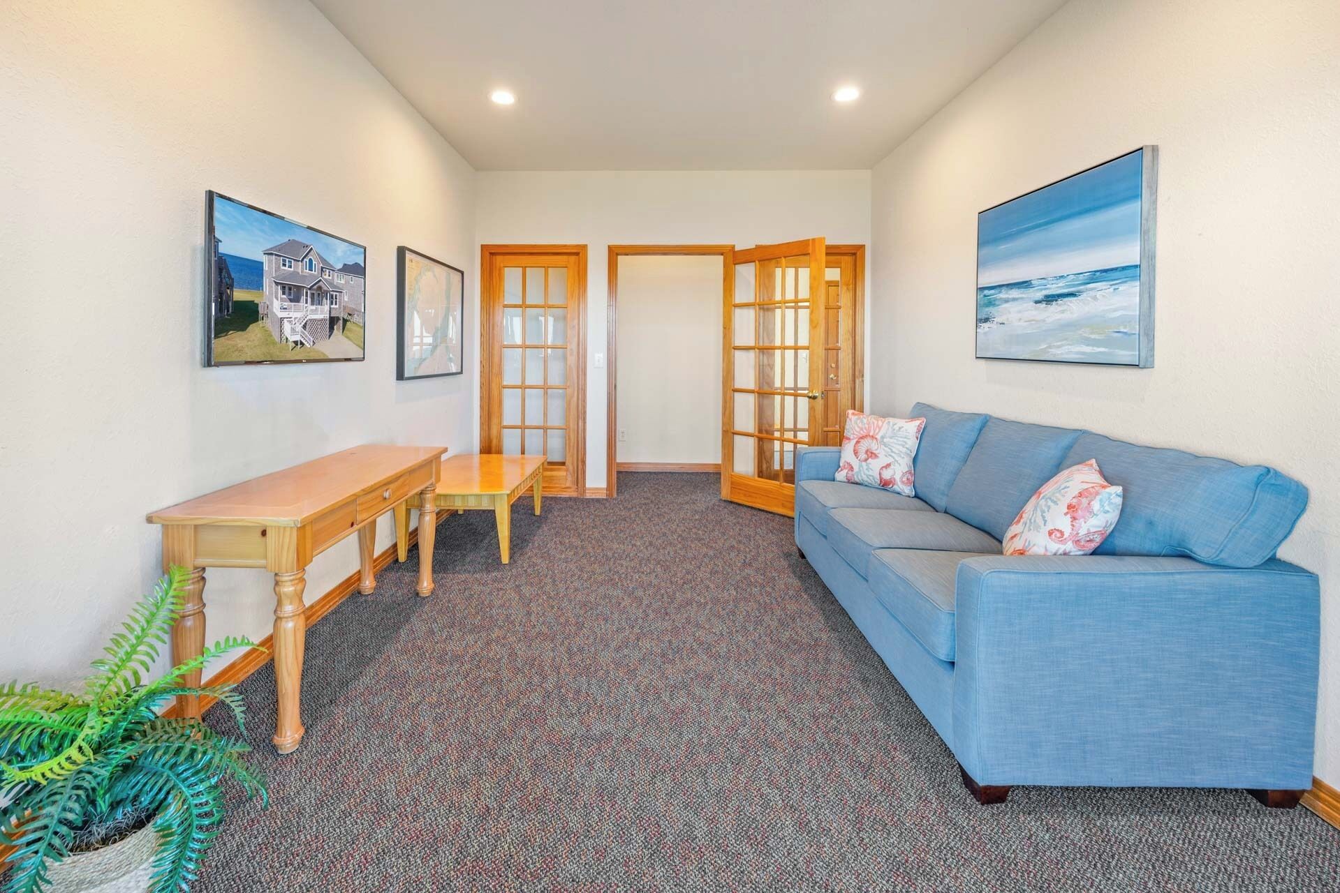 A room with a blue sofa, a wooden table, and a patterned carpet.