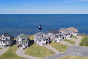 A coastal residential area with houses featuring balconies and a view of the sea. - Soundfront w/ Hot Tub, Media Room, Windsports Access, Community Pool/Boat Dock (Avon)