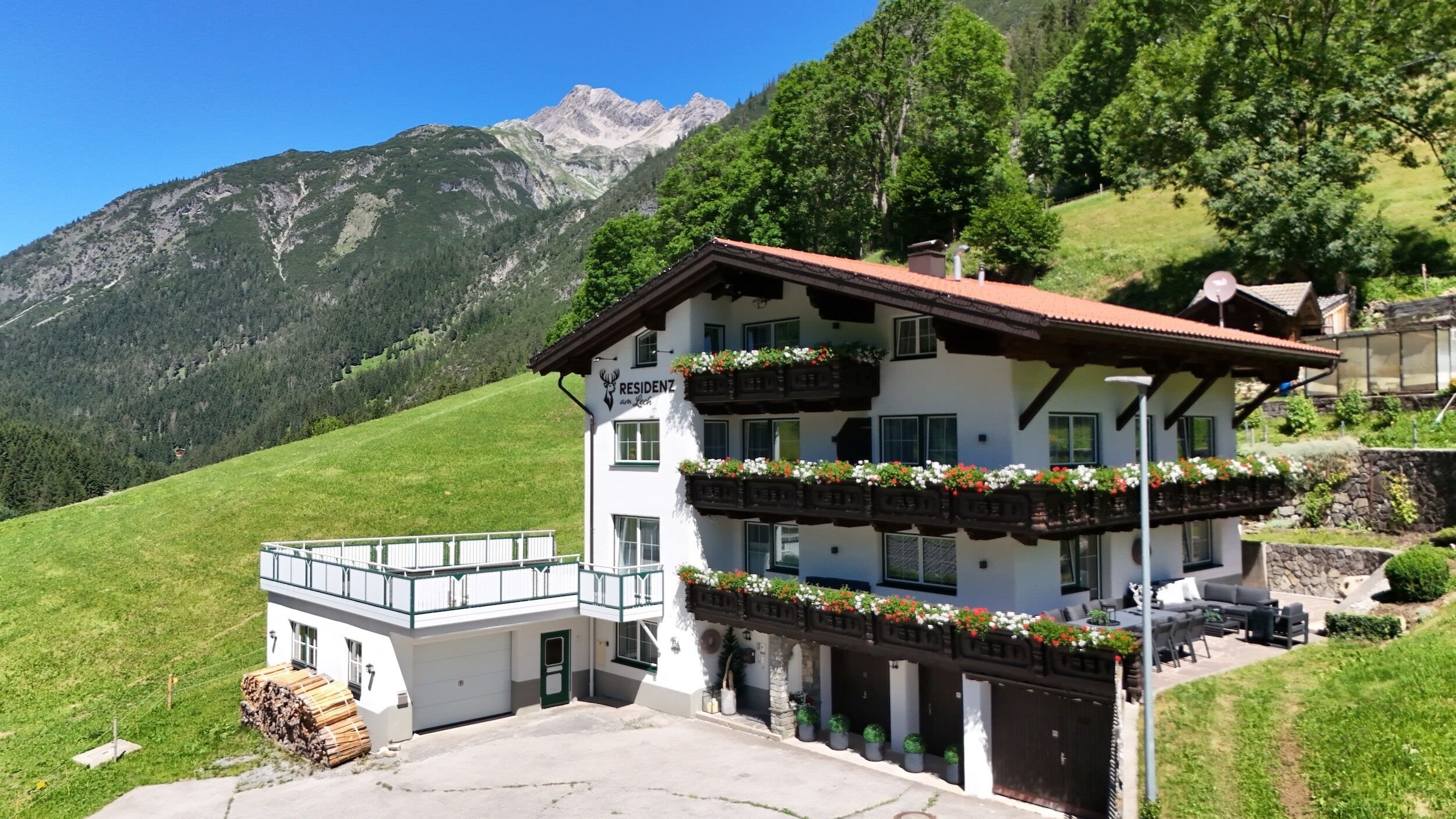 Un immeuble de deux étages doté de balcons, d’un garage et offrant une vue sur les montagnes.