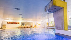 An indoor swimming pool with a water feature, seating area, and a visible reception desk. - Residenz am Lech - Wohnung 2 (Steeg, Lechtal)