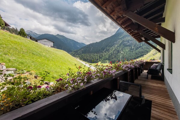 A wooden deck with a view of a mountainous landscape.