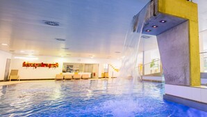 An indoor swimming pool with a water feature, seating area, and a visible reception desk. - Residenz am Lech - Wohnung 4 (Steeg, Lechtal)