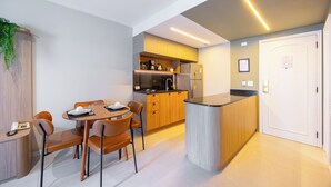 Una cocina moderna con una isla central, armarios de madera y una zona de comedor con sillas y una mesa.