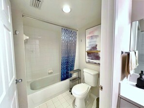 Un baño con bañera, inodoro y zona de ducha.