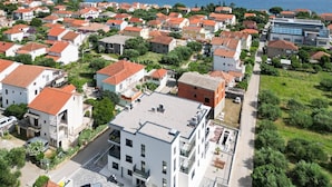 Ein Küstenwohngebiet mit einer Mischung aus modernen und traditionellen Gebäuden, mit Balkonen und Blick auf das Meer.