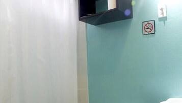A bathroom with a toilet, a sink, a towel rack, and a trash bin.