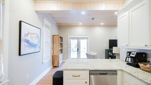 Une cuisine moderne avec des meubles blancs, un plan de travail en granit et un lave-vaisselle.