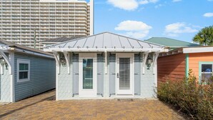 A small, single-story building with a gabled roof and a brick-paved entrance.
