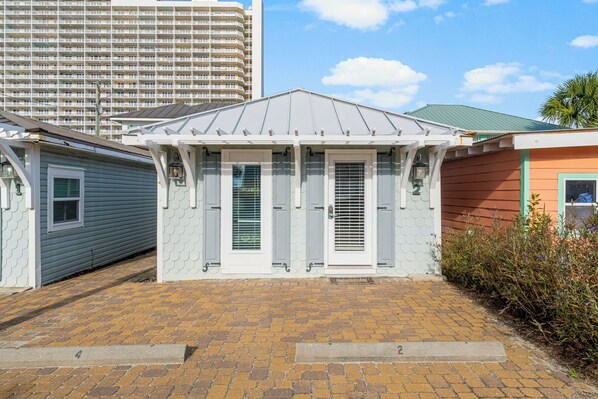 A small, single-story building with a gabled roof and a brick-paved entrance. - Family beach escape w/ daily fun passes (Panama City Beach)