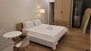 Une chambre à coucher moderne, comprenant un lit, une table de chevet, une chaise et une armoire.
