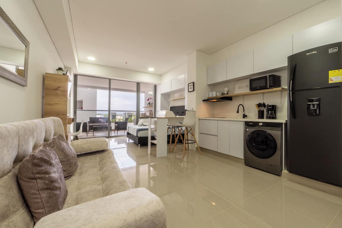 A modern apartment with a living room, kitchen, and balcony.