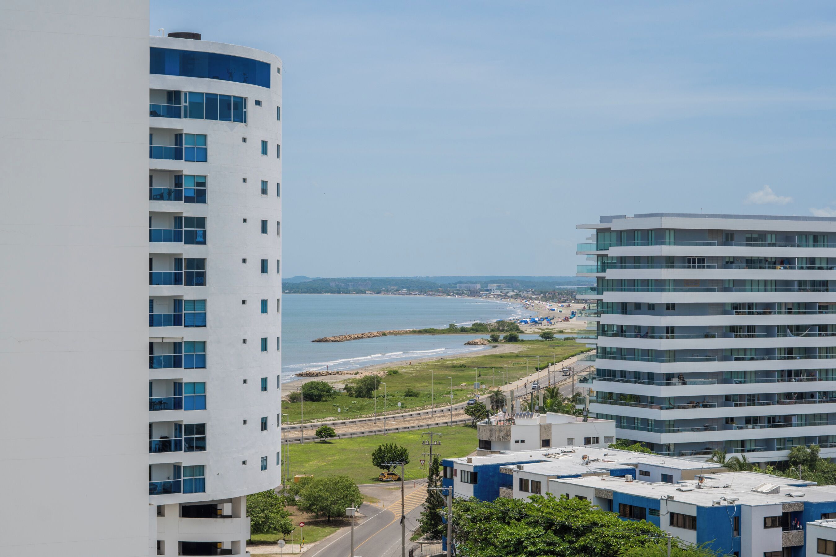 Un immeuble de grande hauteur, doté de nombreux étages, de grandes fenêtres et offrant une vue sur une plage et l’océan.