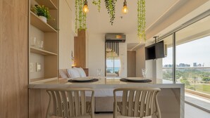 Una cocina moderna con comedor, televisor y vista panorámica de la ciudad.