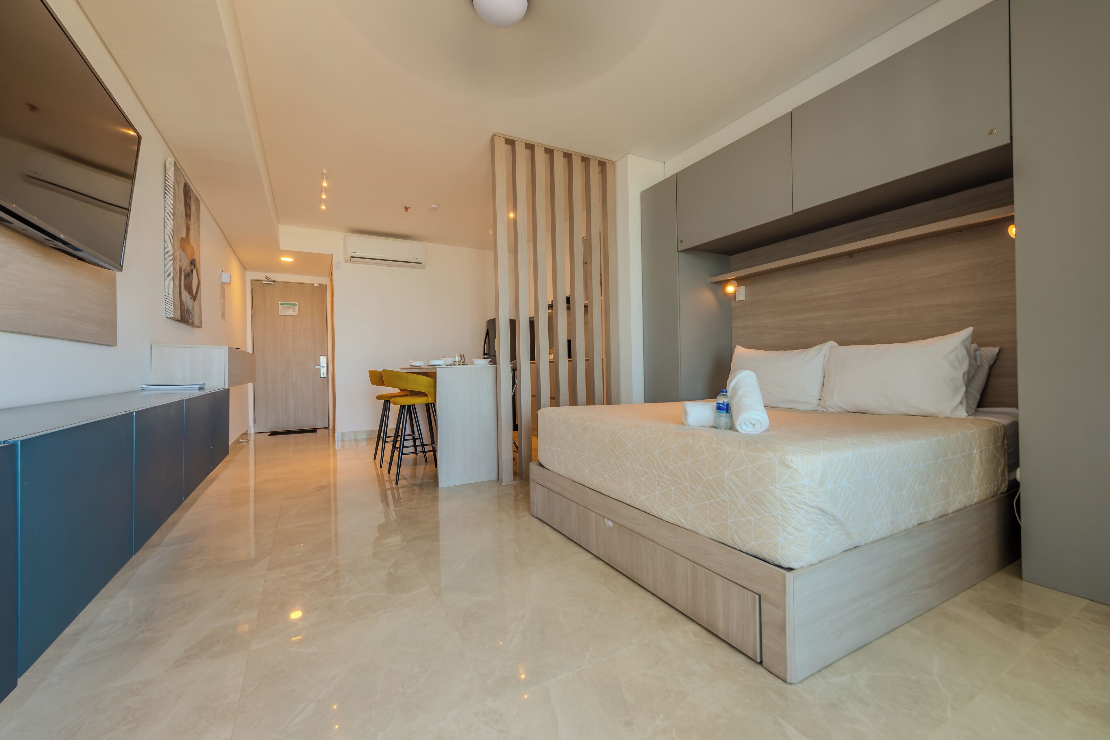 A modern bedroom with a large bed, a desk, and a chair.