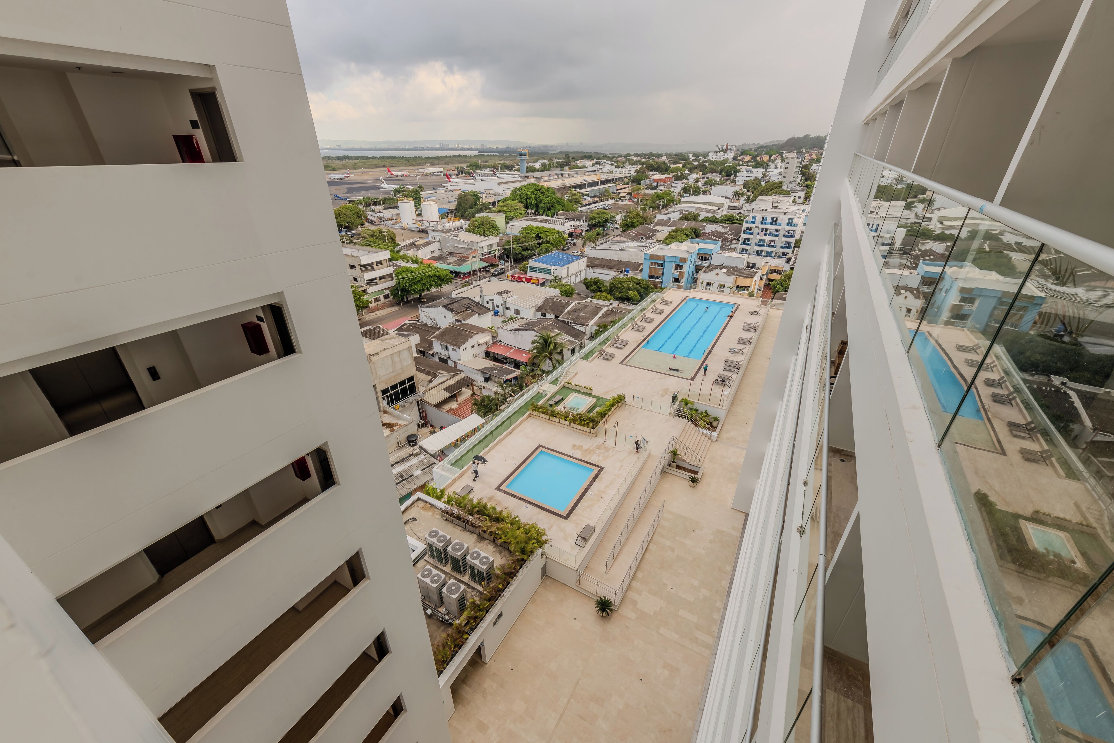 Un immeuble de grande hauteur doté de nombreux balcons et d’une piscine sur le toit.