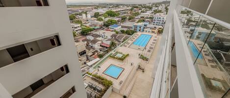Un immeuble de grande hauteur doté de nombreux balcons et d’une piscine sur le toit.