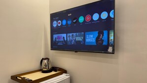 A flat-screen TV mounted on a wall displaying various streaming apps and TV shows. - New White Pyramids Inn (Giza)