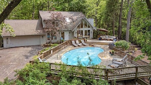 A house with a swimming pool, deck chairs, and a covered seating area. - Juniper Presents: Walk to Beach Retreat - Pool, Hot Tub & Fire Pit (Michiana)