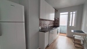 A kitchen with white cabinets, a black countertop, and a window with a view.
