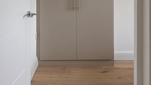 A closed wardrobe with a handle, a white door, and a wooden floor. - Picktheplace Kensington Lux Apartments III (London)