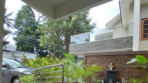 A modern outdoor area with a black metal staircase, potted plants, and a stone wall.